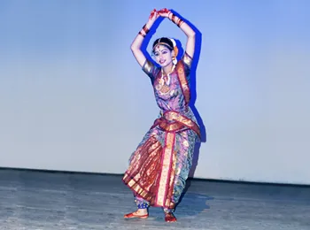 A student performing a classical dance on stage at the RGB event